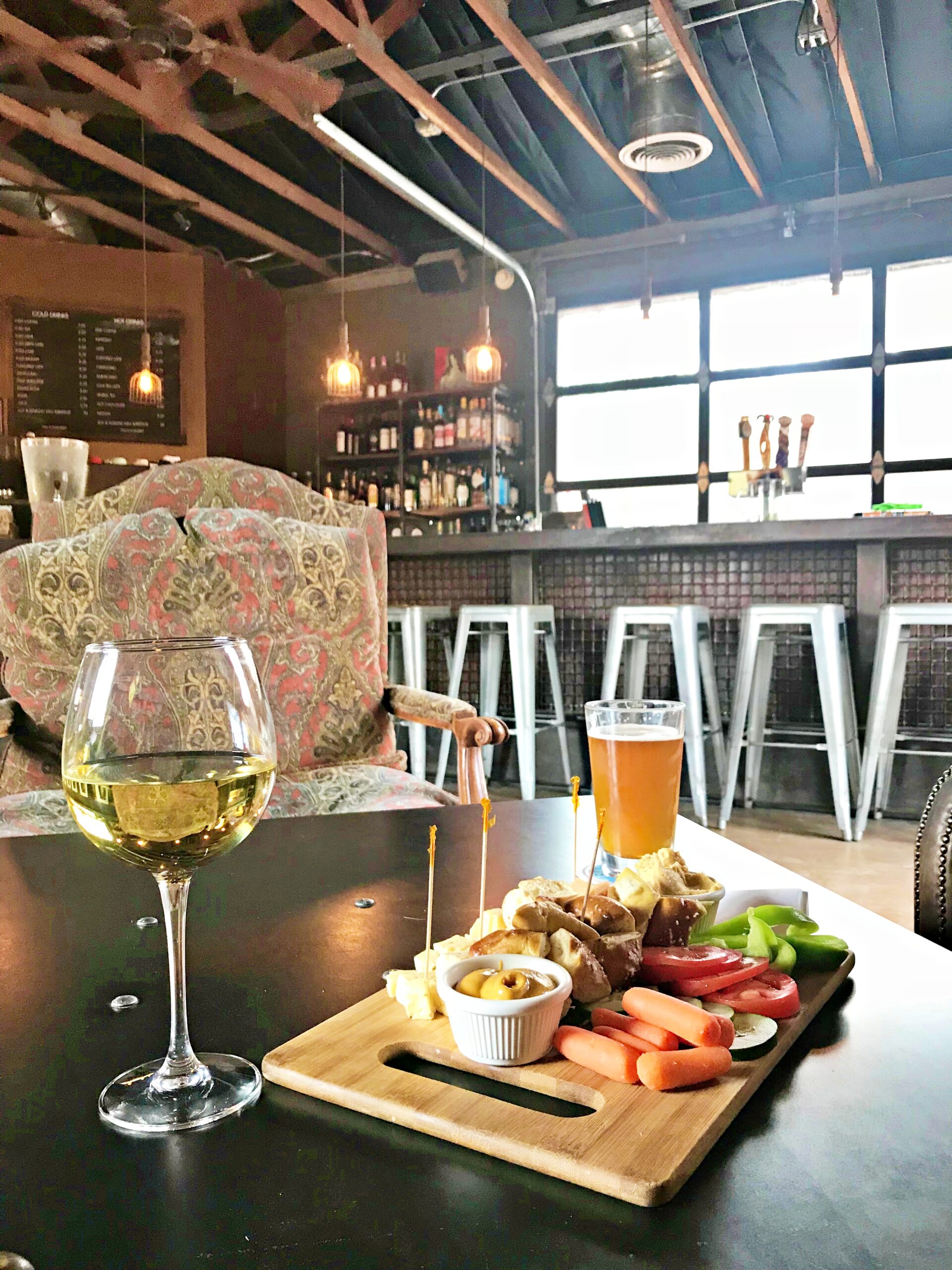 Glass of wine with a pub board in a rustic bar setting.