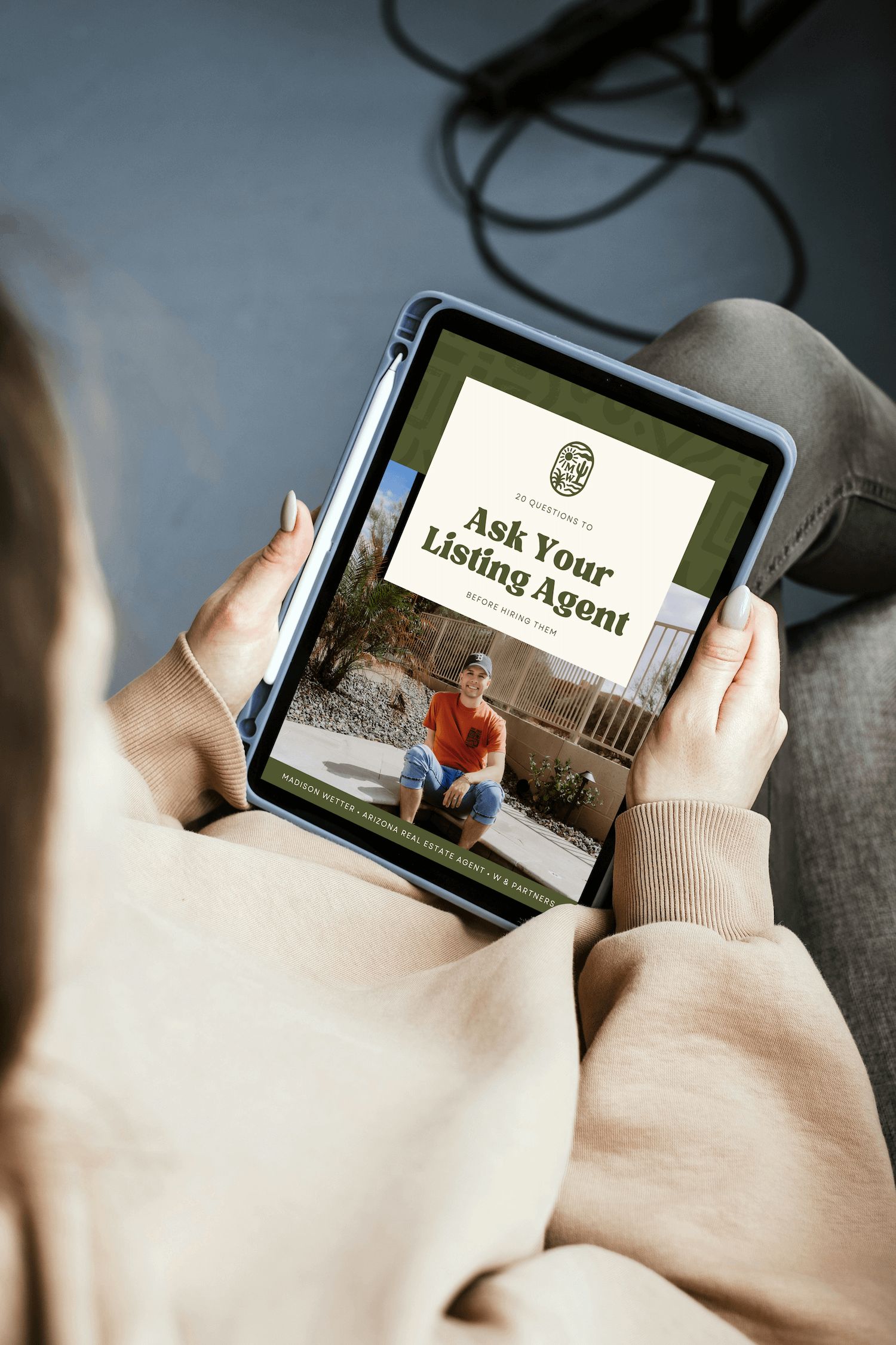 Person holding a tablet displaying Madison Wetter’s guide 20 Questions to Ask Your Listing Agent before hiring, Arizona real estate resource